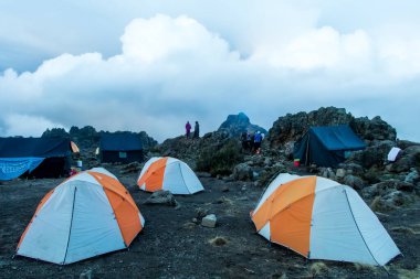 Kenya, Tanzanya 'daki Kilimanjaro Dağı' ndaki çakıl taşlarının üzerinde turuncu çadırlar. Yüksek kalite fotoğraf