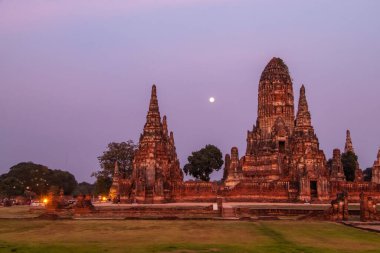 Antik tapınaklar, Wat, Ayutthaya, Tayland 'daki Budist heykeller. Tarihi kırmızı tuğla yapılar ve tapınaklar. Turuncu gün batımı, canlı renkler. Parlak dolunay. İnsan yok. Yüksek kalite fotoğraf