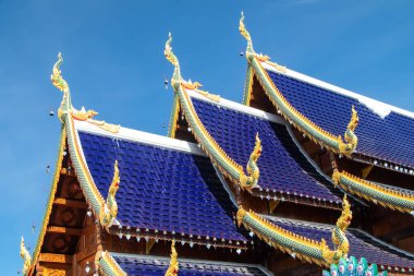 Mavi kiremitli çatı, tapınağın altın süslemeleri, Tayland 'da su. Parlak mavi gökyüzü. Yüksek kalite fotoğraf