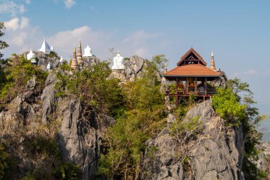 Wat Phutthabat Sutthawat, tepedeki tapınak ve yeşil tepe ve kayadaki stupa. Yüksek uçurumlar ve renkli tapınaklar. Yüksek kalite fotoğraf
