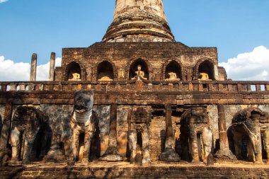 Tayland 'daki Sukhothai Tarihi Parkı' ndaki antik tapınakların detayları. Tarihi kırmızı tuğla yapılar ve tapınaklar. Yeşil gras ve mavi gökyüzü. Büyük Buda heykelleri. İnsan yok. Yüksek kalite fotoğraf