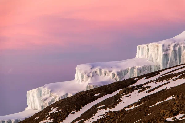 肯尼亚 坦桑尼亚 乞力马扎罗山 日出时山坡上的冰川 粉色晨光 褐色砾石 白色的冰和雪 高质量的 五彩缤纷的 充满活力的照片 — 图库照片
