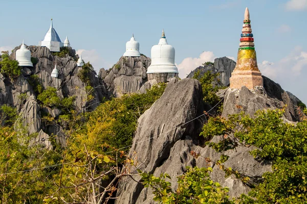 Wat Phutthabat Sutthawat, tepedeki tapınak ve yeşil tepe ve kayadaki stupa. Yüksek uçurumlar ve renkli tapınaklar. Yüksek kalite fotoğraf