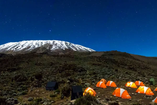 橙色帐篷在夜间从乞力马扎罗山前的内部照明 星星和银河清晰可见 高质量的照片 — 图库照片