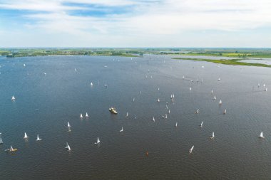 Sneek, Friesland, Hollanda 'da bulunan Sneekermeer adlı bir gölün insansız hava aracı görüntüsü. Arka planda mavi gökyüzü ve yeşil çayırlar var. Yüksek kalite fotoğraf