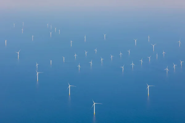 Kuzey Denizi, Avrupa 'da rüzgar türbinleriyle kıyı açıklarındaki rüzgar tarlalarının havadan görüntüsü. Beyaz rüzgar değirmenleri ve türbinleri çok farklı boyutlardadır. Mavi, sakin ve düz deniz. Yüksek kalite fotoğraf