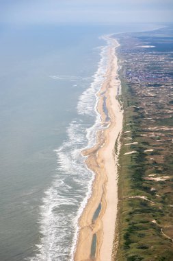 Hollanda kıyı şeridinin altın plajdaki dalgaları ve Hollanda 'yı koruyan kum tepelerini gösteren hava görüntüsü. Yüksek kalite fotoğraf