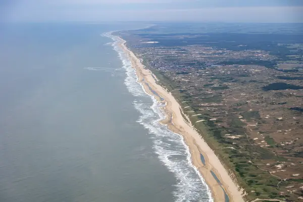 Hollanda kıyı şeridinin altın plajdaki dalgaları ve Hollanda 'yı koruyan kum tepelerini gösteren hava görüntüsü. Yüksek kalite fotoğraf