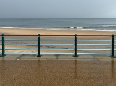 Walkway 'deki deniz kenarındaki nane rengi tırabzan ya da İngiltere' nin Newcastle kentindeki Whitley Körfezi 'nde altın plajlı ve dalgalı sahilde gezinti. Yüksek kalite fotoğraf