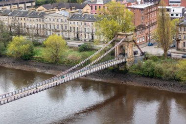 İskoçya 'nın Glasgow şehrindeki Clyde nehri üzerindeki Güney Portland St Askılık Köprüsü. Az sayıda yürüyen insan ve nehir kıyısındaki tarihi şehir evleri. Yüksek kalite fotoğraf