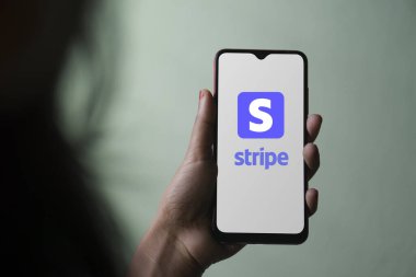 Dhaka, Bangladeş - 05 Aralık 2023: Ekranda şerit uygulaması olan bir el telefonu tutuyor. Stripe uygulaması bir finans şirketi hizmetidir.