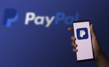 Dhaka, Bangladeş - 05 Aralık 2023: Ekranda Paypal uygulaması olan bir el telefonu tutuyor. Paypal uygulaması bir finans şirketi.