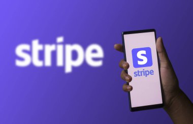 Dhaka, Bangladeş - 06 Aralık 2023: Ekranda şerit uygulaması olan bir el telefonu tutuyor. Stripe uygulaması bir finans şirketi..