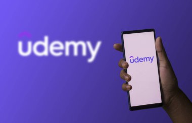 Dhaka, Bangladeş - 06 Aralık 2023: Ekranda Udemy uygulaması olan bir el telefonu tutuyor. Udemy uygulaması bir finans şirketi..
