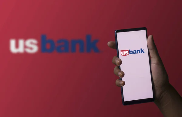 stock image Dhaka, Bangladesh - 06 December 2023: A hand holding a phone with the us bank logo on the screen. Us bank is a financial company base in USA.