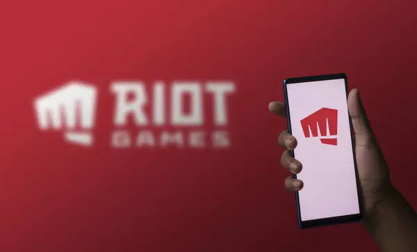 Dhaka, Bangladeş - 07 Aralık 2023: Ekranda Riot oyunları logosu olan bir el telefonu tutuyor.