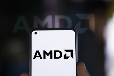 Dhaka, Bangladesh - 30 December 2023: Hand holding a phone with AMD logo.  Advanced Micro Devices, Inc. is an American multinational semiconductor company. clipart