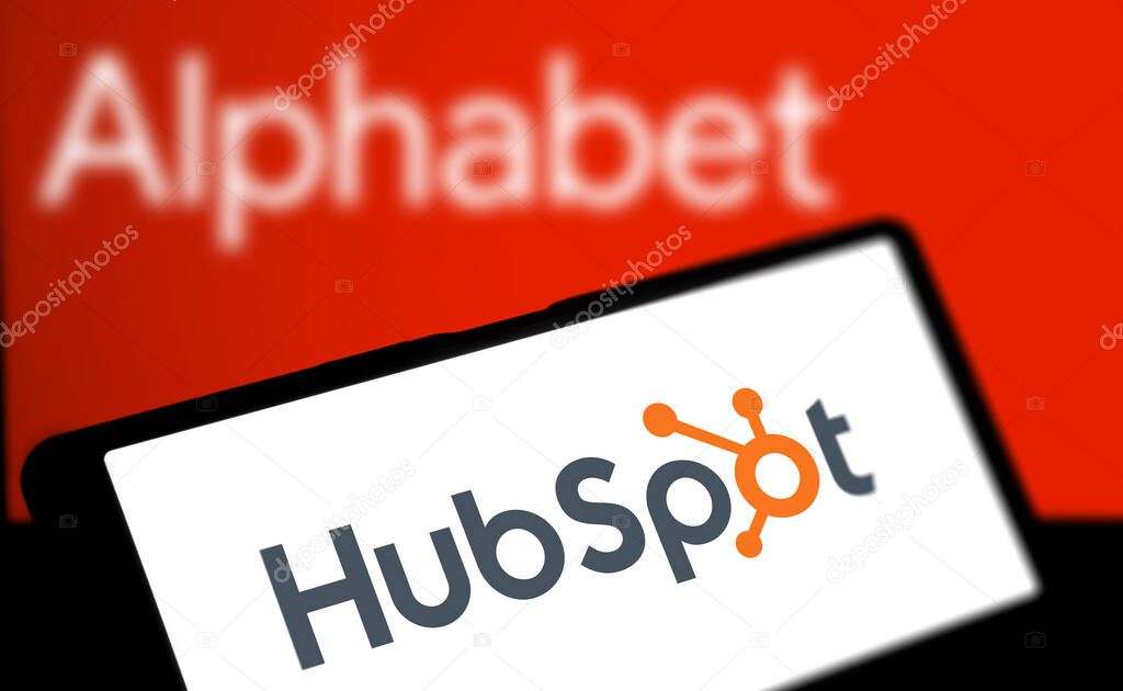 Dhaka, Bangladesh- 06 Apr 2024: Hubspot logo is displayed on smartphone and alphabet logo in the background.