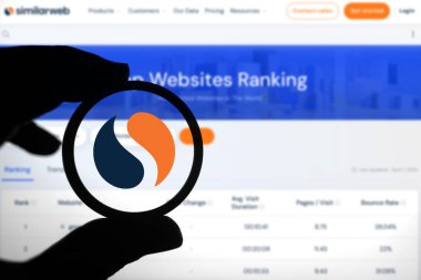 Dhaka, Bangladeş - 10 Nisan 2024: Benzerlik Ağı logosunu incelemek için bir büyüteç tutan kişi.