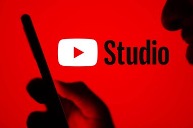 Dhaka, Bangladeş - 23 Temmuz 2024: Youtube Stüdyo logosu akıllı telefon tutan bir adamın arkasında görüntülendi.
