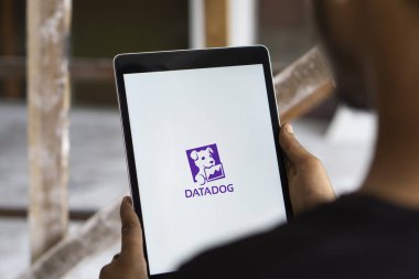 Dhaka, Bangladesh- 11 Aug 2024: DataDog logo is displayed on iPad. Datadog is a SaaS platform that monitors cloud applications. clipart