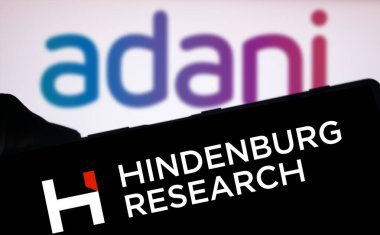 Dhaka, Bangladeş - 18 Ağustos 2024: Hindenburg Araştırma logosu ön plandaki akıllı telefon ekranında belirgin bir şekilde gösteriliyor, arka planda Adani logosu bulanıklaşıyor.