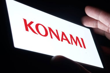 Dhaka, Bangladesh- 09 Nov 2024: Konami logo is displayed on smartphone. Konami is a Japanese multinational entertainment company. clipart