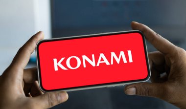 Dhaka, Bangladesh- 09 Nov 2024: Konami logo is displayed on smartphone. Konami is a Japanese multinational entertainment company. clipart