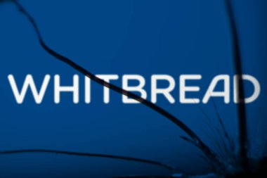Dhaka, Bangladeş - 8 Aralık 2024: Broekn camında beyaz ekmek logosu görünüyor. Whitbread, İngiliz çok uluslu otel ve restoran şirketidir..