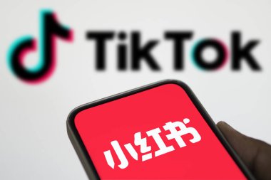 Dhaka, Bangladeş - 16 Ocak 2025: Xiaohongshu (REDnote) logosu arka planda akıllı telefon ve tiktok logosu ile gösterilir.