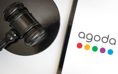 Dhaka, Bangladesh- 21 jan 2025: An iPad displays the Agoda logo alongside a judge's gavel. Agoda is an online travel agency. clipart