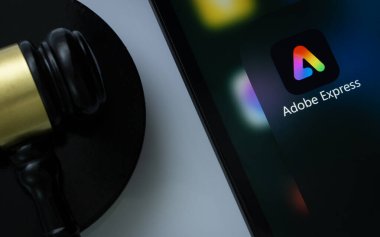 Dhaka, Bangladeş - 01 Mart 2025: Yargıcın tokmağının yanında Adobe Express uygulamasını gösteren iPad ekranının yakın çekimi.