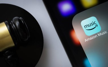 Dhaka, Bangladeş - 01 Mart 2025: Bir yargıcın tokmağının yanında Amazon müzik uygulamasını gösteren iPad ekranına yakın çekim.