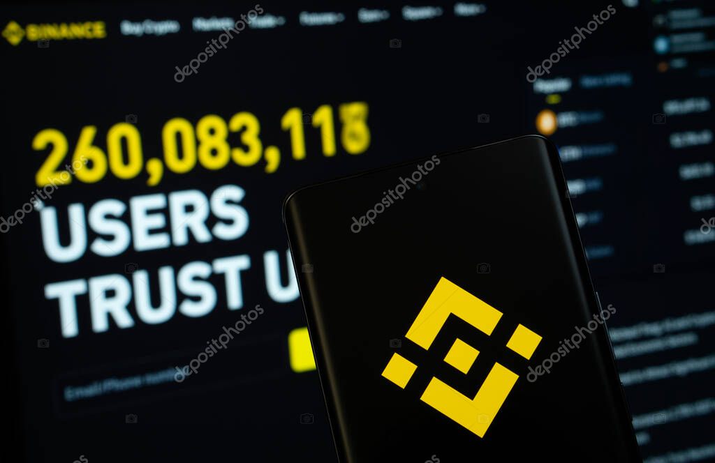 Dhaka, Bangladesh- 02 March 2025: Binance logo is displayed on a smartphone screen, with the binance website visible on a computer screen in the background.