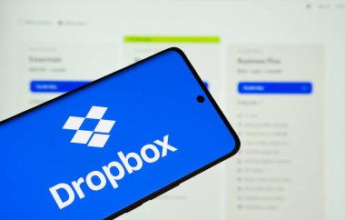 Dhaka, Bangladeş - 05 Mart 2025: Dropbox logosu, arka plandaki bilgisayar ekranında dropbox web sitesi ile bir akıllı telefon ekranında görüntülenir.
