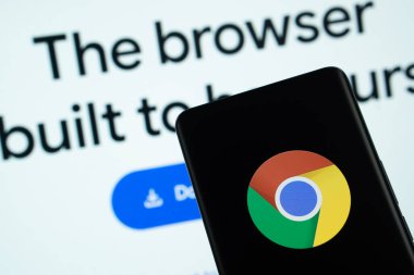 Dhaka, Bangladeş - 05 Mart 2025: Krom logosu bir akıllı telefon ekranında gösteriliyor ve krom web sitesi arka planda bir bilgisayar ekranında görülüyor.