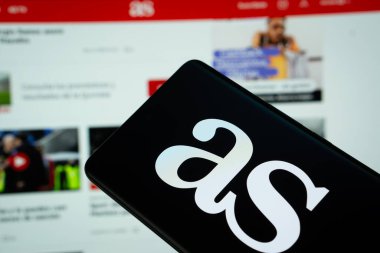 Dhaka, Bangladeş - 12 Mart 2025: İspanyol AS gazetesinin logosu akıllı telefon ekranında gösteriliyor ve as.com sitesi arka planda bir bilgisayar ekranında görülebiliyor.