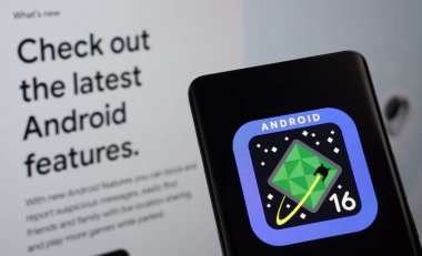 Dhaka, Bangladeş - 15 Mart 2025: Android 16 'nın logosu akıllı telefon ekranında gösteriliyor, android web sitesi arka planda bir bilgisayar ekranında görülüyor.