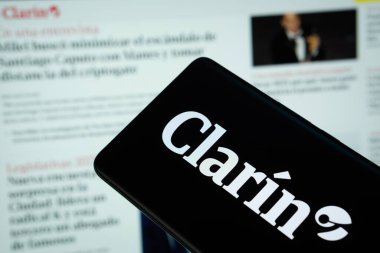 Dhaka, Bangladesh - 16 March 2025: The logo of the Clarin is displayed on a smartphone screen, and the website clarin.de is visible on a computer screen in the background. clipart