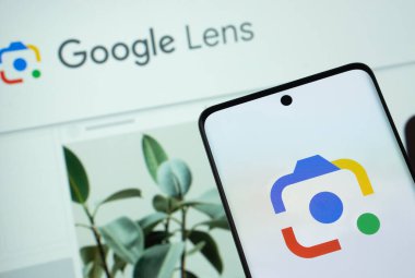 Dhaka, Bangladeş - 16 Mart 2025: Google lensinin logosu akıllı telefon ekranında gösteriliyor ve Google lensi arka plandaki bir bilgisayar ekranında görülebiliyor.