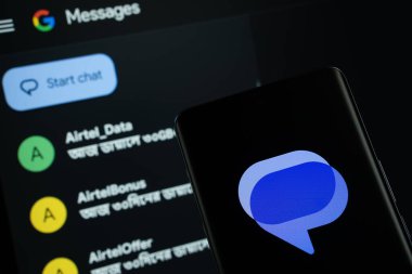 Dhaka, Bangladeş - 16 Mart 2025: Google mesajlarının logosu akıllı telefon ekranında gösteriliyor ve web sitesi Google iletileri arka plandaki bir bilgisayar ekranında görülebiliyor.