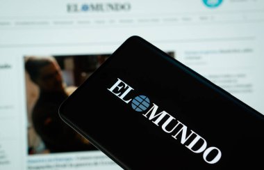 Dhaka, Bangladeş - 16 Mart 2025: EL MUNDO 'nun logosu akıllı telefon ekranında gösteriliyor ve El mundo web sitesi arka plandaki bilgisayar ekranında görülebiliyor.