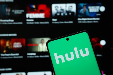 Dhaka, Bangladeş - 16 Mart 2025: Hulu 'nun logosu akıllı telefon ekranında gösteriliyor ve hulu web sitesi arka plandaki bilgisayar ekranında görülebiliyor.