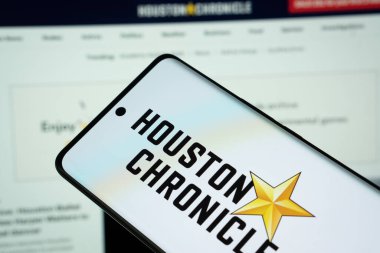 Dhaka, Bangladeş - 16 Mart 2025: Houston Chronicle gazetesinin logosu akıllı telefon ekranında gösteriliyor ve Houston Chronicle sitesi arka plandaki bilgisayar ekranında görülebiliyor.