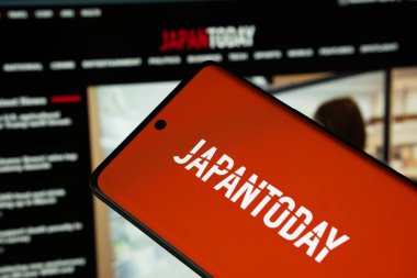Dhaka, Bangladeş - 17 Mart 2025: Japonya gazetesinin logosu akıllı telefon ekranında sergileniyor ve bugün Japonya sitesi arka planda bir bilgisayar ekranında görülebiliyor..