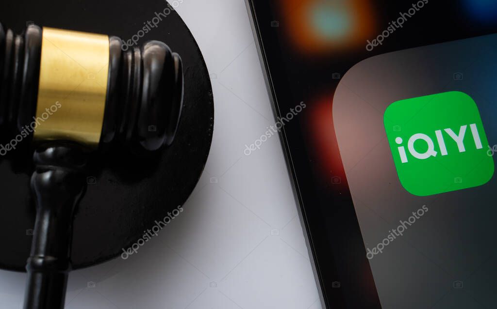Dhaka, Bangladesh- 17 March 2025: A close up of an iPad screen displaying the iqiyi app alongside a judge's gavel.