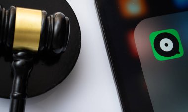 Dhaka, Bangladeş - 17 Mart 2025: Joox uygulamasını hakimin tokmağının yanında gösteren iPad ekranının yakın çekimi.