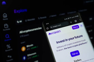 Dhaka, Bangladeş - 17 Mart 2025: Kraken logosu akıllı telefon ekranında gösteriliyor ve kraken web sitesi arka planda bir bilgisayar ekranında görülebiliyor.
