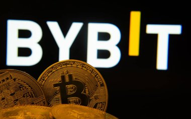 Dhaka, Bangladeş - 11 Nisan 2025: Bitcoin sikkelerine yakın plan arkaplanda Bybit logosu olan bir ekranda görünür.