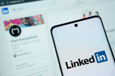 Dhaka, Bangladeş - 17 Mart 2025: Bağlantının logosu akıllı telefon ekranında gösteriliyor ve bağlı olduğu web sitesi arka plandaki bilgisayar ekranında görülebiliyor.
